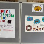 Dwa kolorowe plakaty w języku polskim o wyborach szkolnych i projekcie, wyświetlone na szarej tablicy ogłoszeń.