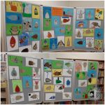 Dziecięce rysunki zwierząt są wyświetlane na szarych tablicach na kolorowej wystawie w bibliotece.