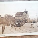Zabytkowe zdjęcie poznańskiego Kaponiery z tramwajami, ludźmi i dorożkami na ulicy miasta.