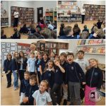 Dzieci w mundurkach szkolnych uczestniczą w wydarzeniu bibliotecznym, słuchając prelegenta i pozując do zdjęć grupowych.