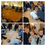 Dzieci w grupach bawiące się i uśmiechnięte w pomieszczeniach, zebrane na podłodze do zajęć i gier.