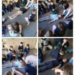 Cztery zdjęcia dzieci ćwiczących techniki pierwszej pomocy na kolegach leżących na podłodze w klasie.