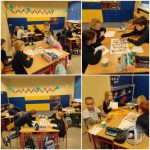 Dzieci siedzą w grupach przy biurkach w klasie, pracując nad kolorowymi grami planszowymi i wspólnymi zajęciami.