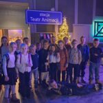 Grupa dzieci pozuje razem w pomieszczeniu przy choince pod napisem stacja Teatr Animacji.