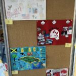 Na tablicy korkowej znajdują się cztery kolorowe plakaty uczniów dotyczące USA, Kanady, Jamajki i Wielkiej Brytanii.