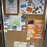 Tablica ogłoszeń przedstawia kolorowe plakaty o Australii, w tym zwierzęta, mapy i rysunki.