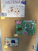 Trzy kolorowe plakaty uczniów o Australii i Wielkiej Brytanii są wyświetlane na tablicy korkowej, ponumerowane 4, 8, 9.