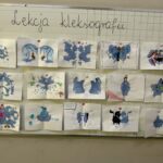 Tablica ogłoszeń przedstawia 16 prac uczniów wykonanych techniką kleksografii (inkblot).