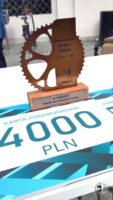 Na stole podczas imprezy stoją puchar o tematyce kolarskiej oraz karta podarunkowa o wartości 4000 PLN.